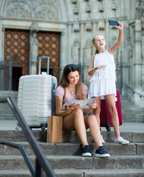 Menina fazendo selfie com telefone durante a viagem com a mãe — Fotografia de Stock