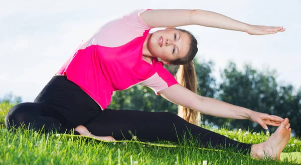 Feminino em camiseta rosa está se alongando — Fotografia de Stock