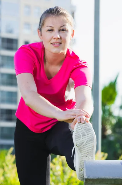 Chica en rosa camiseta está haciendo ejercicio —  Fotos de Stock