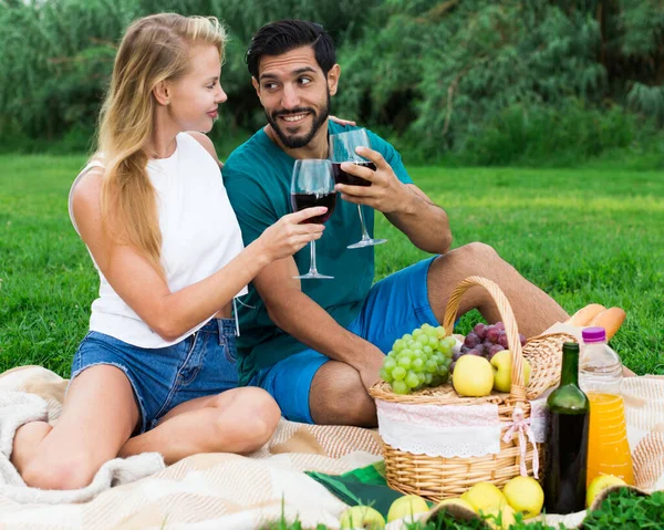 Glimlachend koppel zit met wijnglazen en praten — Stockfoto