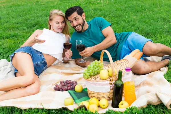 Pareja sonriente está acostada con gafas de vino y hablando —  Fotos de Stock