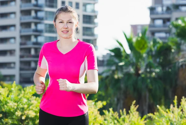 Sportowa dziewczyna w różowym T-shirt jest jogging — Zdjęcie stockowe