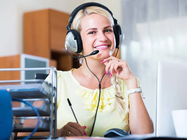 Girl answering the call of technical support and smiling — Stock Photo, Image