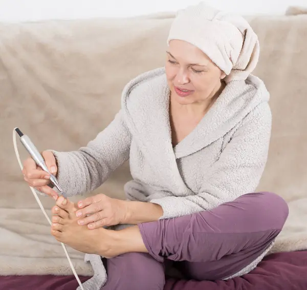 Mujer haciendo pedicura Imágenes De Stock Sin Royalties Gratis