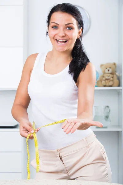 Young woman measures waist — Stock Photo, Image