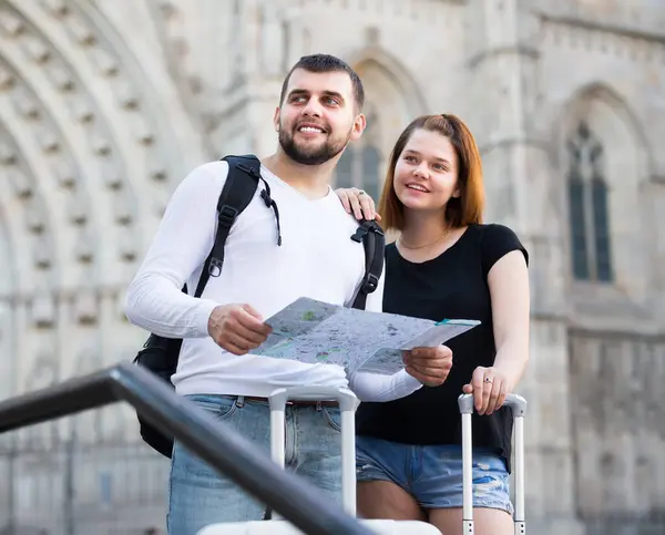 Young tourists with map walking with baggage Royalty Free Stock Images