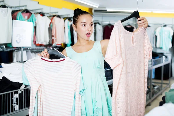 Brunette kiest nieuwe kleding in de winkel — Stockfoto