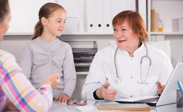 Little girl and mother with mature medical worker Royalty Free Stock Photos