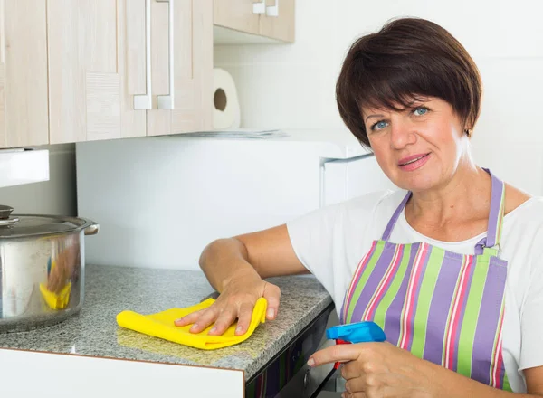 Pensionärskvinna som städar hemma — Stockfoto