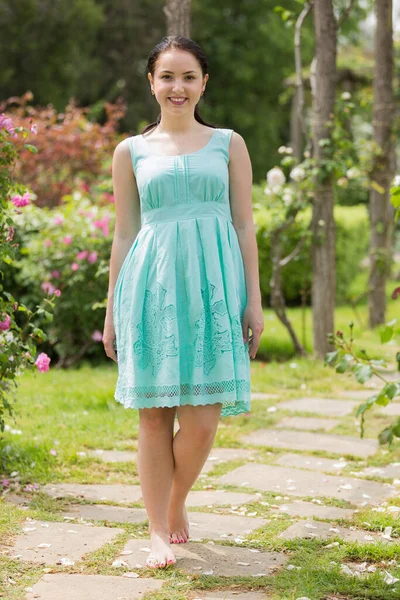 Portrait de jeune femme en robe près des roses dans un parc — Photo