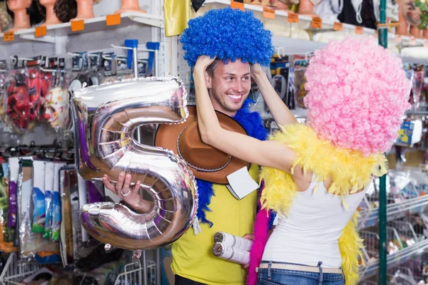 Riendo macho con novia tratando de payaso pelucas —  Fotos de Stock