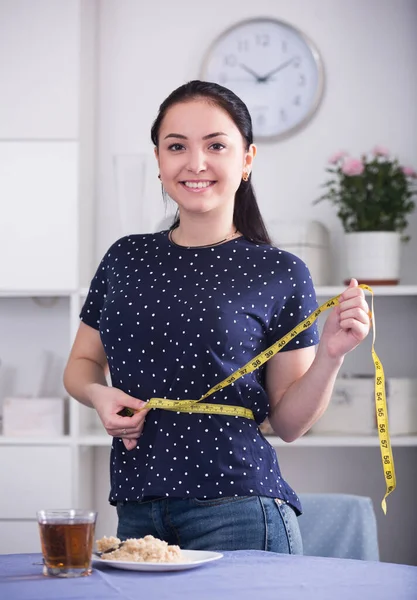 Smiling woman measuring waist — Stock Photo, Image