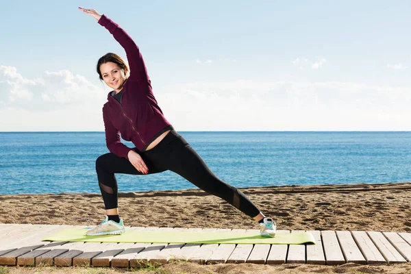 Kvinna som tränar på stranden — Stockfoto