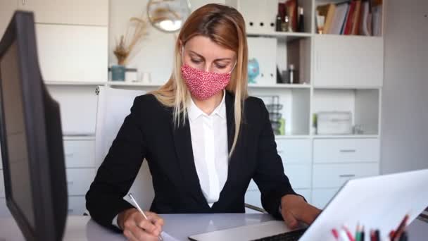 Portrait of positive woman manager in medical mask in office while working day — Stock Video