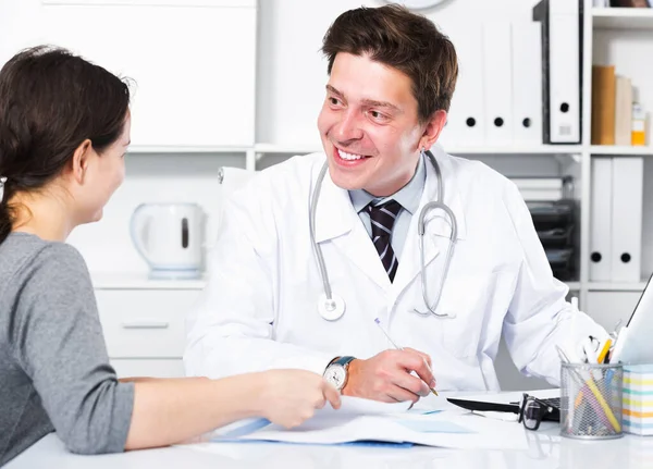 Alegre médico profesional en uniforme hablando con el paciente —  Fotos de Stock