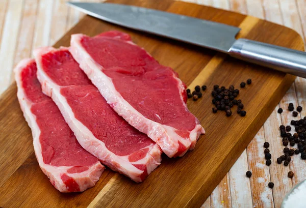 Raw beef tenderloin with spices and bay leaves on wooden board — Stock Photo, Image