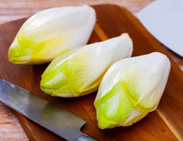 Raw organic endives on wooden table — Stock Photo, Image