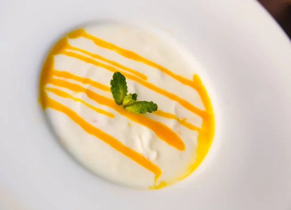 Crema de postre yougurt con puré de maracuyá en el plato —  Fotos de Stock