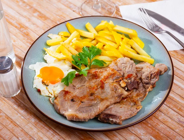 Osztrák ételek: sült burgonya hússal, sonkával és tojással a tányéron közelkép — Stock Fotó