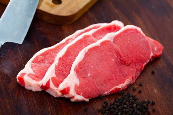 Raw boneless beef with seasonings on wooden background — Stock Photo, Image