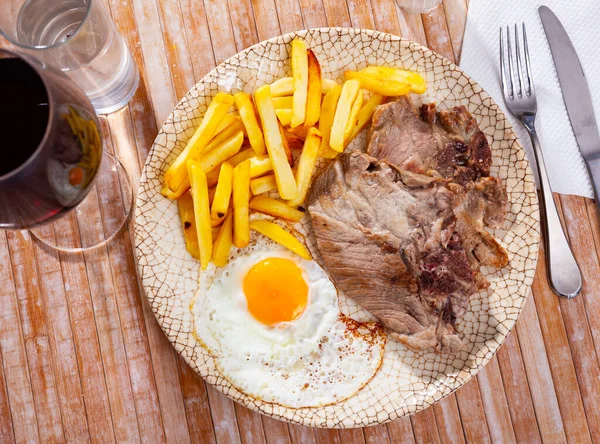 Pommes de terre frites avec viande, jambon et oeuf en assiette close-up — Photo