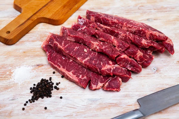 Close up de pedaços de striploin na mesa de madeira — Fotografia de Stock