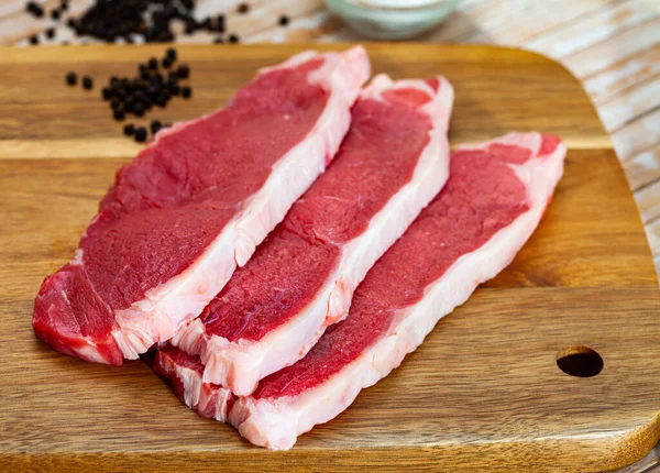 Kawałki wołowiny z groszkiem gorzkiej papryki na desce do krojenia — Zdjęcie stockowe