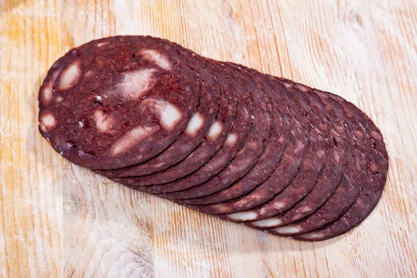 Rodajas finas de botifarra negra catalana sobre fondo de madera — Foto de Stock