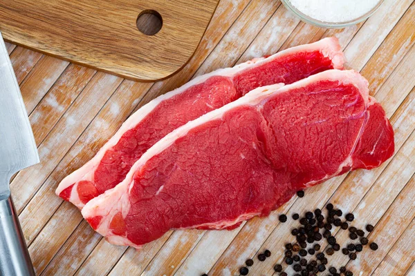 Sliced pieces of raw beef tenderloin on wooden cutting board — Stock Photo, Image