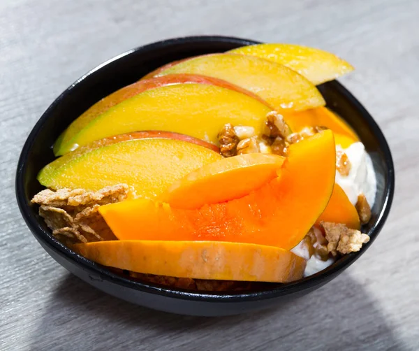 Mango und gebackener Kürbis mit Joghurt, Flocken und Walnüssen — Stockfoto