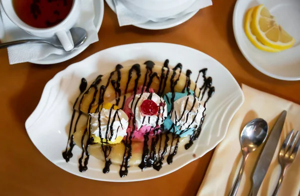 Banana partida con helado, crema batida y salsa de chocolate — Foto de Stock