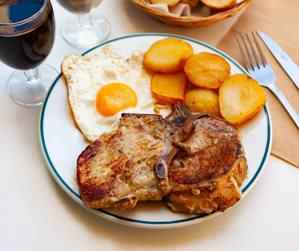 Assiette avec côtelette de porc avec pommes de terre et œufs brouillés — Photo