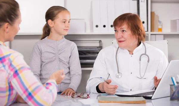 Little girl and mother with mature medical worker Royalty Free Stock Photos