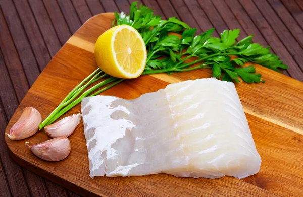 Filete de anguila rosa sobre tabla de cortar con limón y perejil. — Foto de Stock