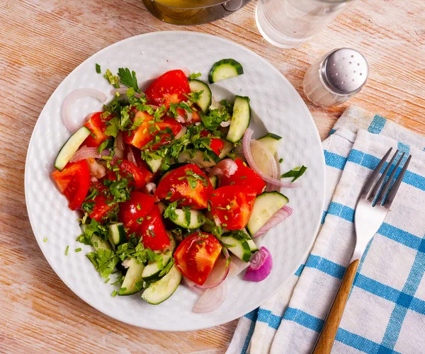 Salade van verse tomaten, komkommers, rode ui, peterselie — Stockfoto
