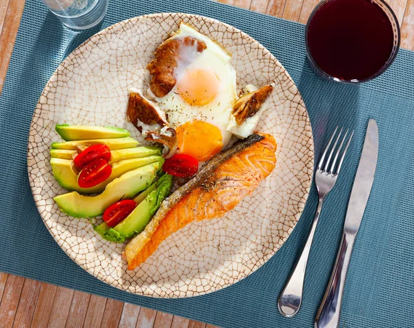 Somon filetosu, avokado ve çırpılmış yumurta tabağı. — Stok fotoğraf
