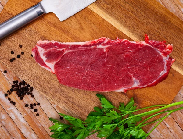 Morceaux tranchés de filet de bœuf cru sur planche à découper en bois — Photo