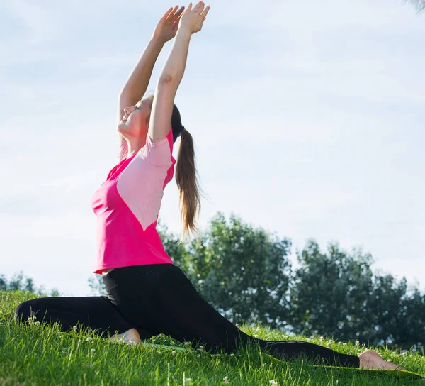 Mujer de 20-30 años practicando estiramiento en camiseta rosa —  Fotos de Stock