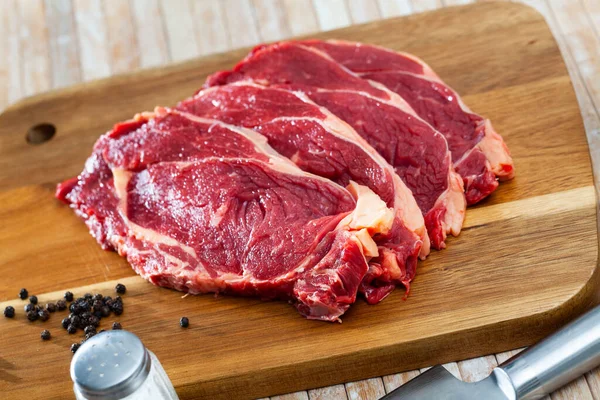 Zbliżenie kawałków marmurkowej wołowiny na drewnianym stole — Zdjęcie stockowe