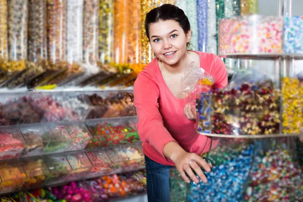 Woman in store is picking up candies — Stock Photo, Image