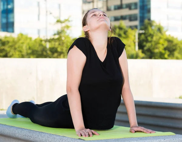 Mujer joven durante el yoga de entrenamiento al aire libre —  Fotos de Stock