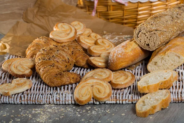 Various kinds of bread and bakery products on table — Stock Photo, Image