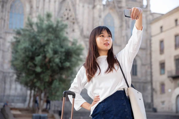 Entusiasta turista china haciendo selfie en el fondo de hito — Foto de Stock