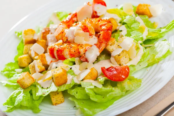 Salada César fresca com camarões no prato no restaurante — Fotografia de Stock
