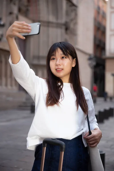 Charming female tourist making selfie on the background of landmark — Stock Photo, Image