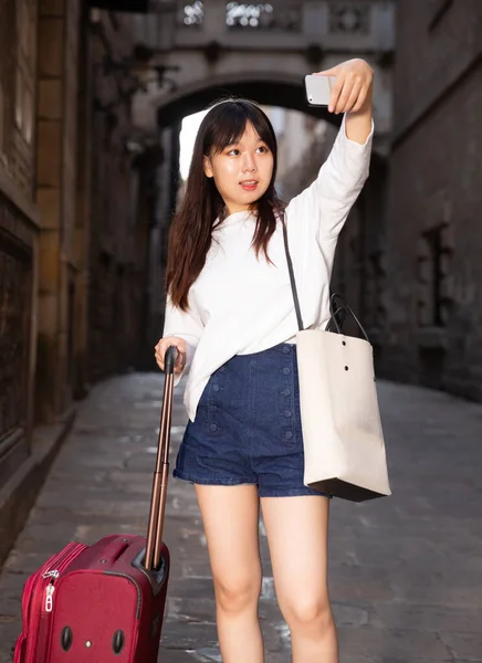 Csinos kínai női turista, hogy szelfi a háttérben mérföldkő — Stock Fotó