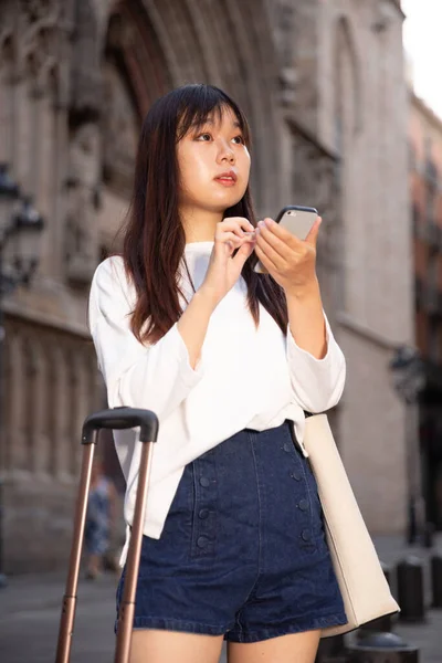 Toeristisch Chinees meisje met behulp van haar telefoon in de stad op vakantie — Stockfoto