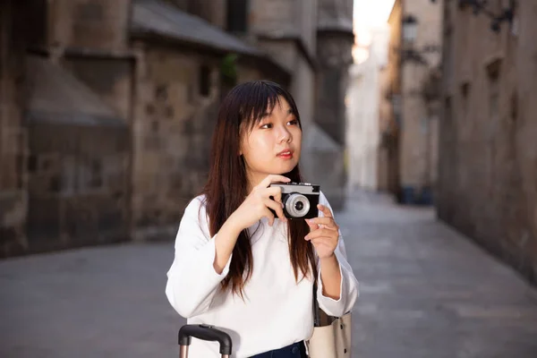 Junge Chinesin bummelt mit Gepäck durch die Stadt und macht Fotos von Sehenswürdigkeiten — Stockfoto