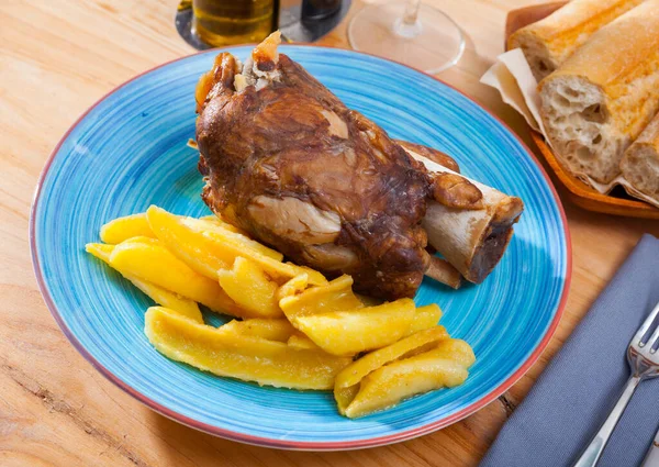 Close up of delicious baked pork knuckle with potatoes, served — Stock Photo, Image