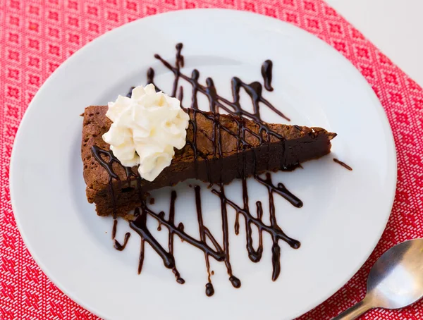 Bolo de brownie doce com creme de chocolate e manteiga servido no prato — Fotografia de Stock